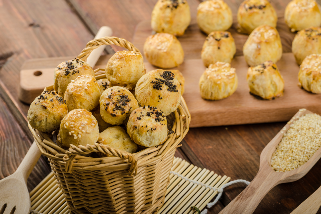 Cheesy bites with garlic on a rustic wooden board.