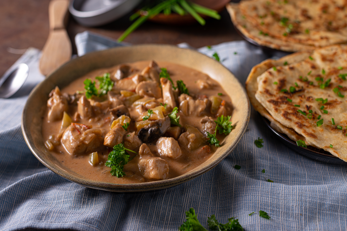 Creamy mushroom chicken served with sauce and herbs.