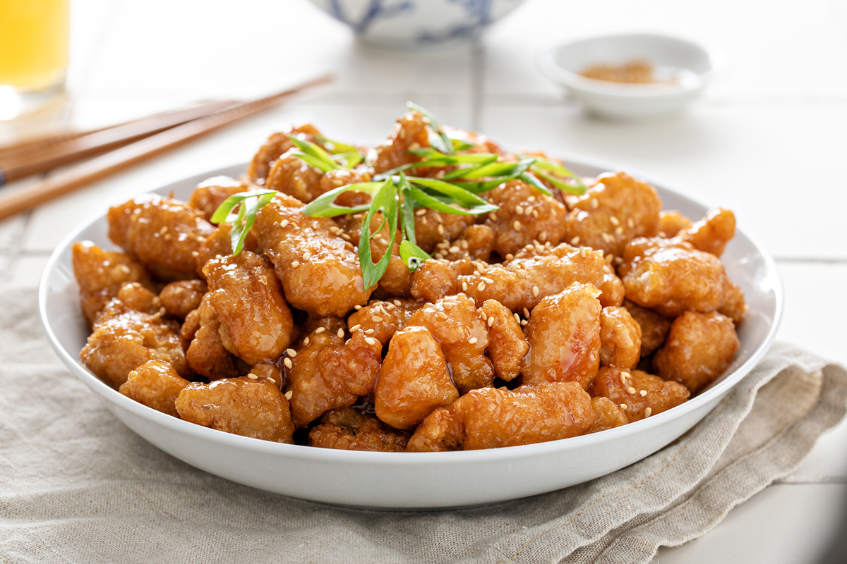 Hot honey chicken bites served with dipping sauce and fresh herbs.