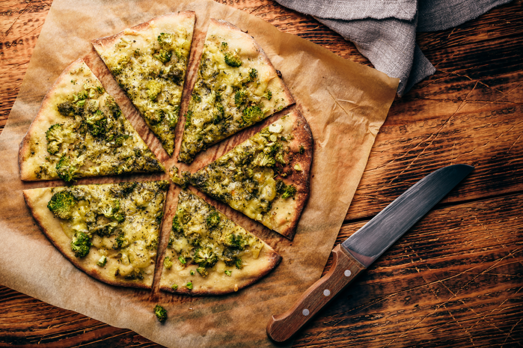 A freshly baked broccoli and cheese pizza with a golden crust and melted mozzarella and Parmesan cheese.