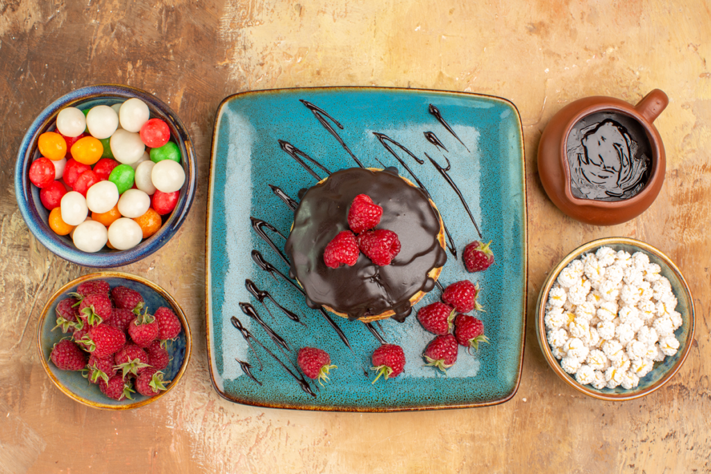 Fluffy puffy pancakes drizzled with chocolate sauce, topped with fresh berries.