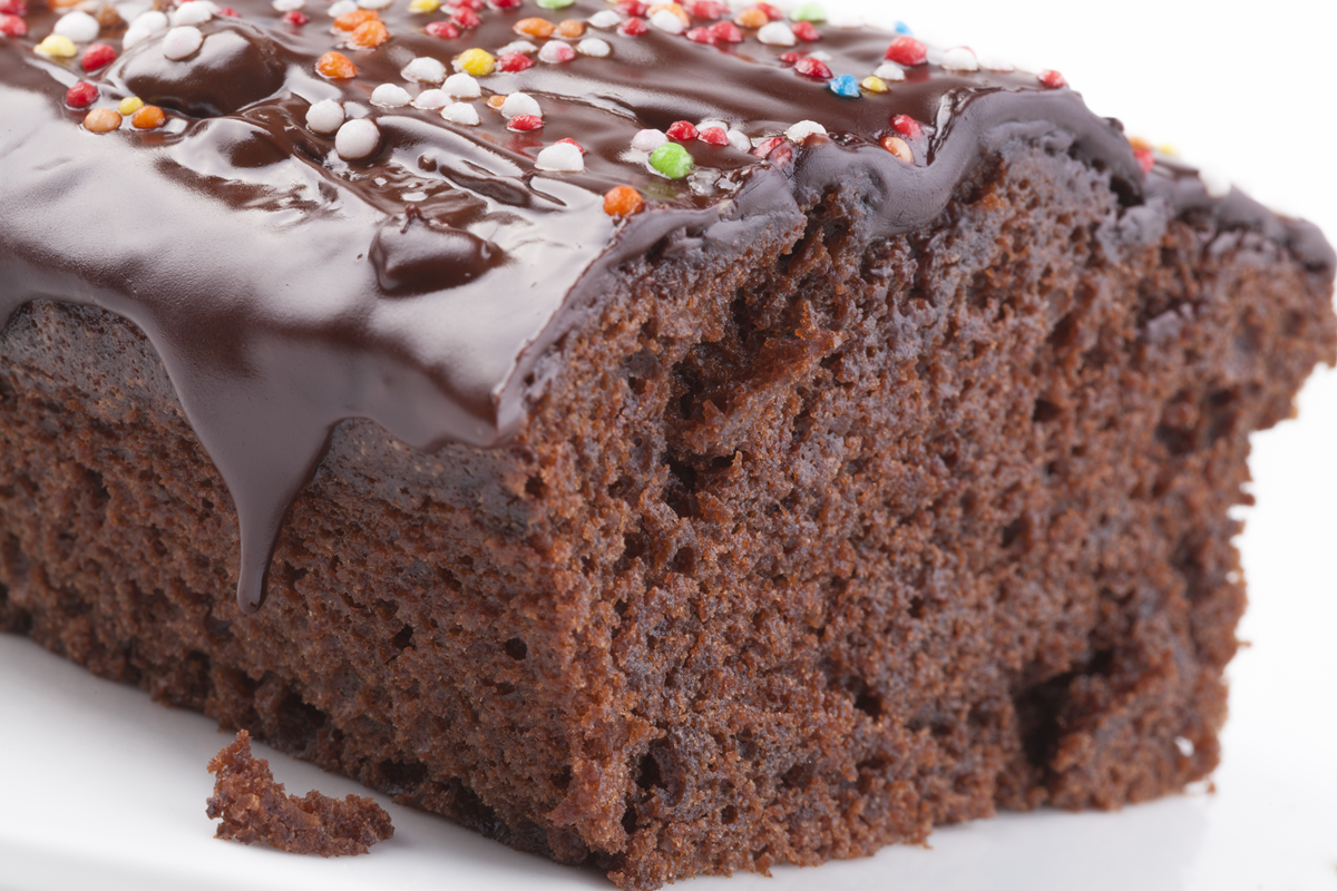 Slice of moist chocolate sponge cake with rich chocolate frosting