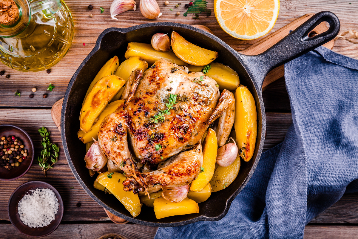 One pan garlic roasted chicken with golden brown skin and roasted vegetables.