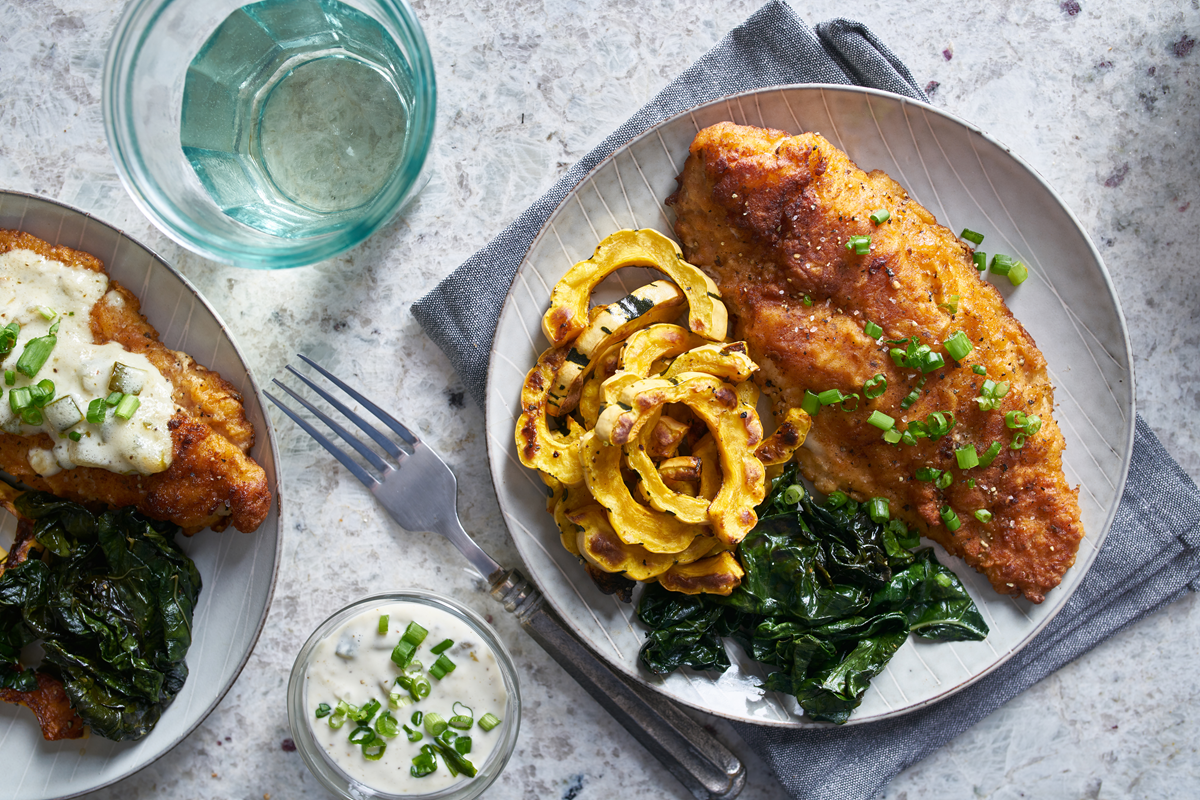 Catfish fillet served with roasted squash and fresh spinach leaves