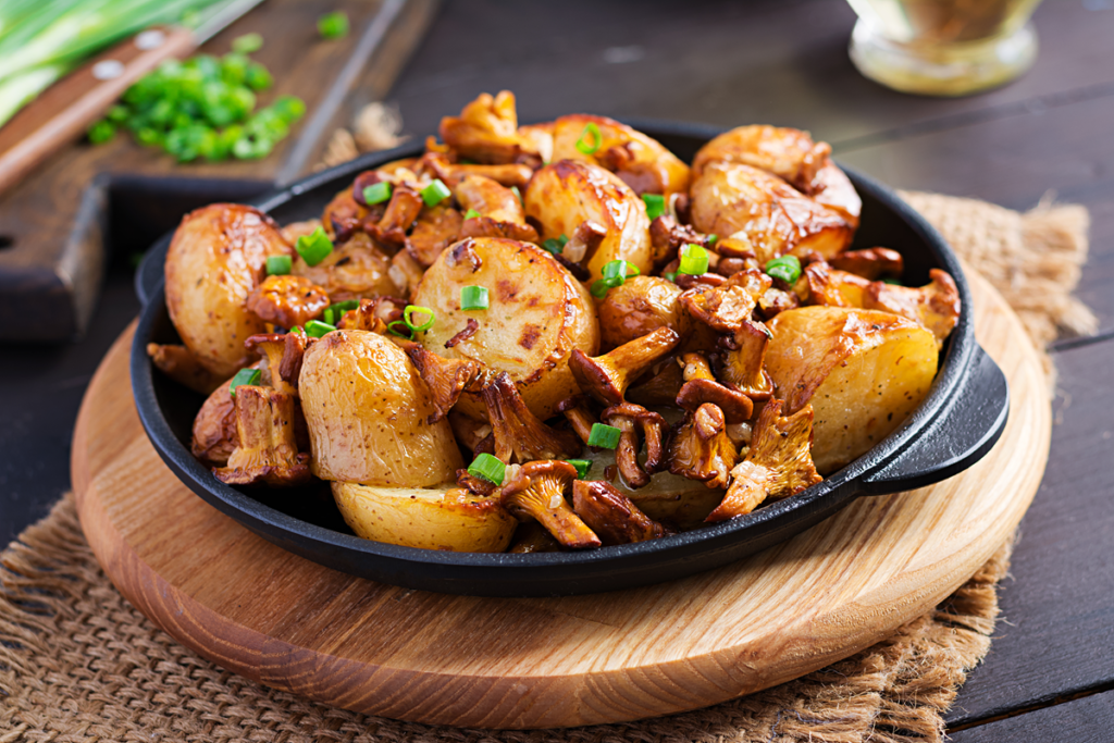 Garlic herb roasted potatoes with chanterelle mushrooms in a cast iron skillet.