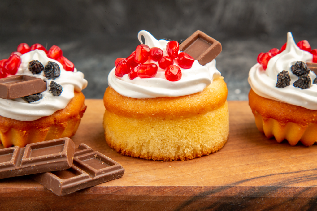 Berry cakes topped with chocolate pieces, whipped cream, and fresh berries.