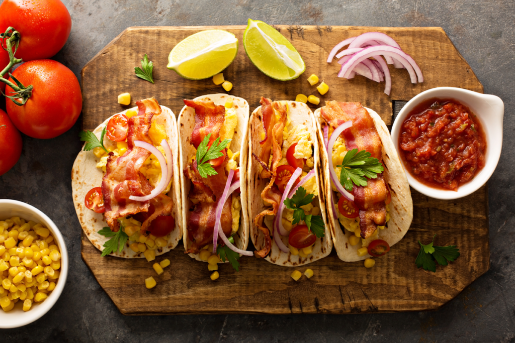 Breakfast tacos with scrambled eggs, bacon, and fresh vegetables