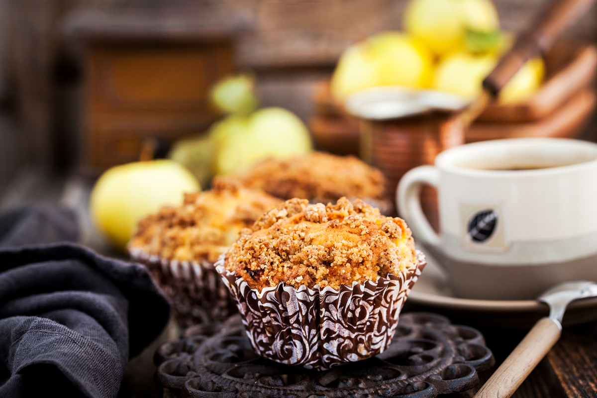 Fresh homemade apple and cinnamon crumble muffins with a cup of coffee